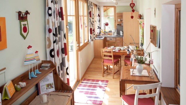 Vacation apartment, © Hannes Engelbrecht Cozy vacation apartment with wooden furniture, dining table and decorative curtains.