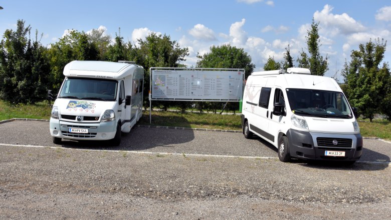Wohnmobilstellplatz, © Stadtgemeinde Mistelbach Zwei Wohnmobile auf einem Stellplatz mit Infotafel im Hintergrund.