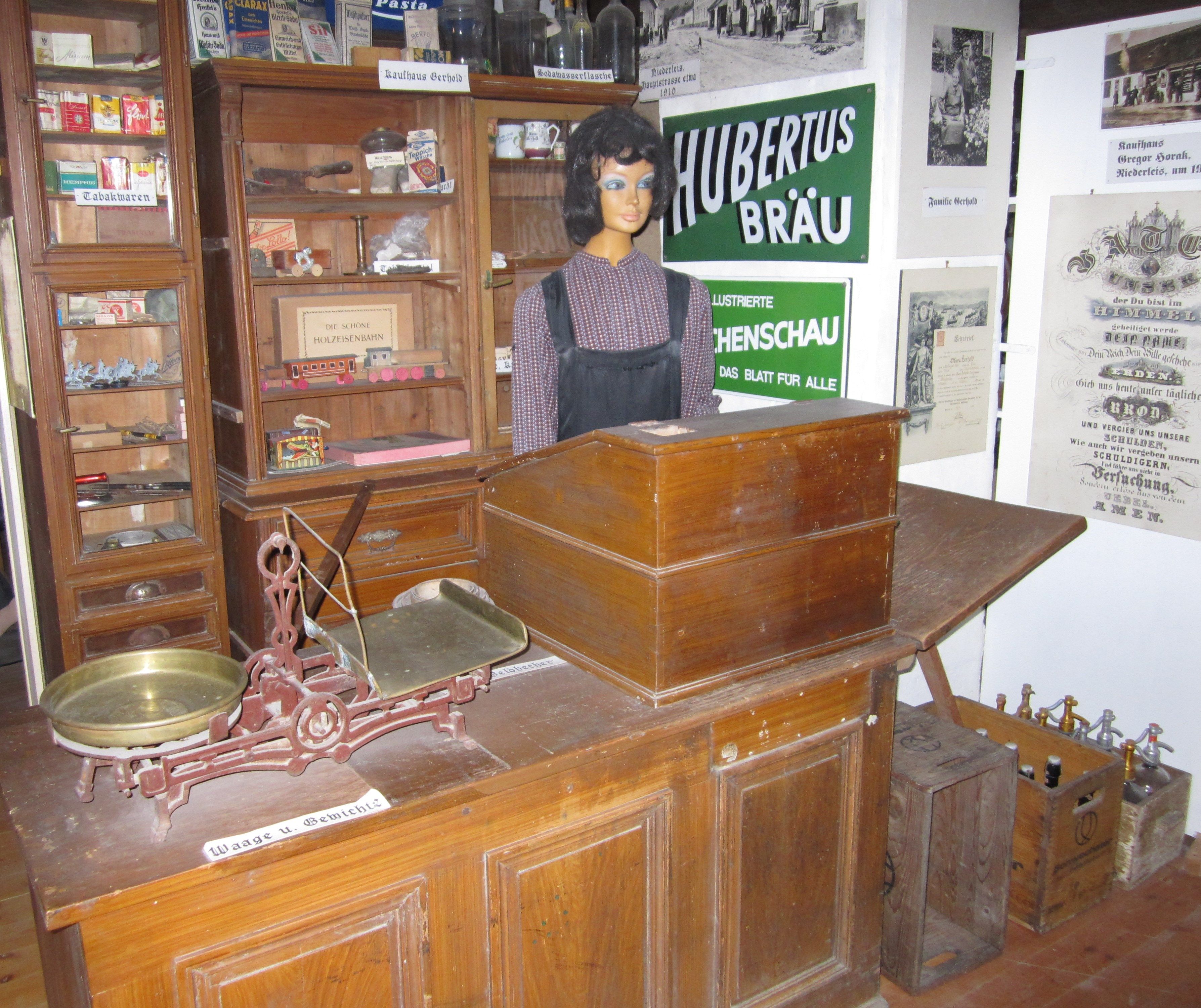 Historic store in the Niederleis local history museum with scales, mannequin and old advertising signs.