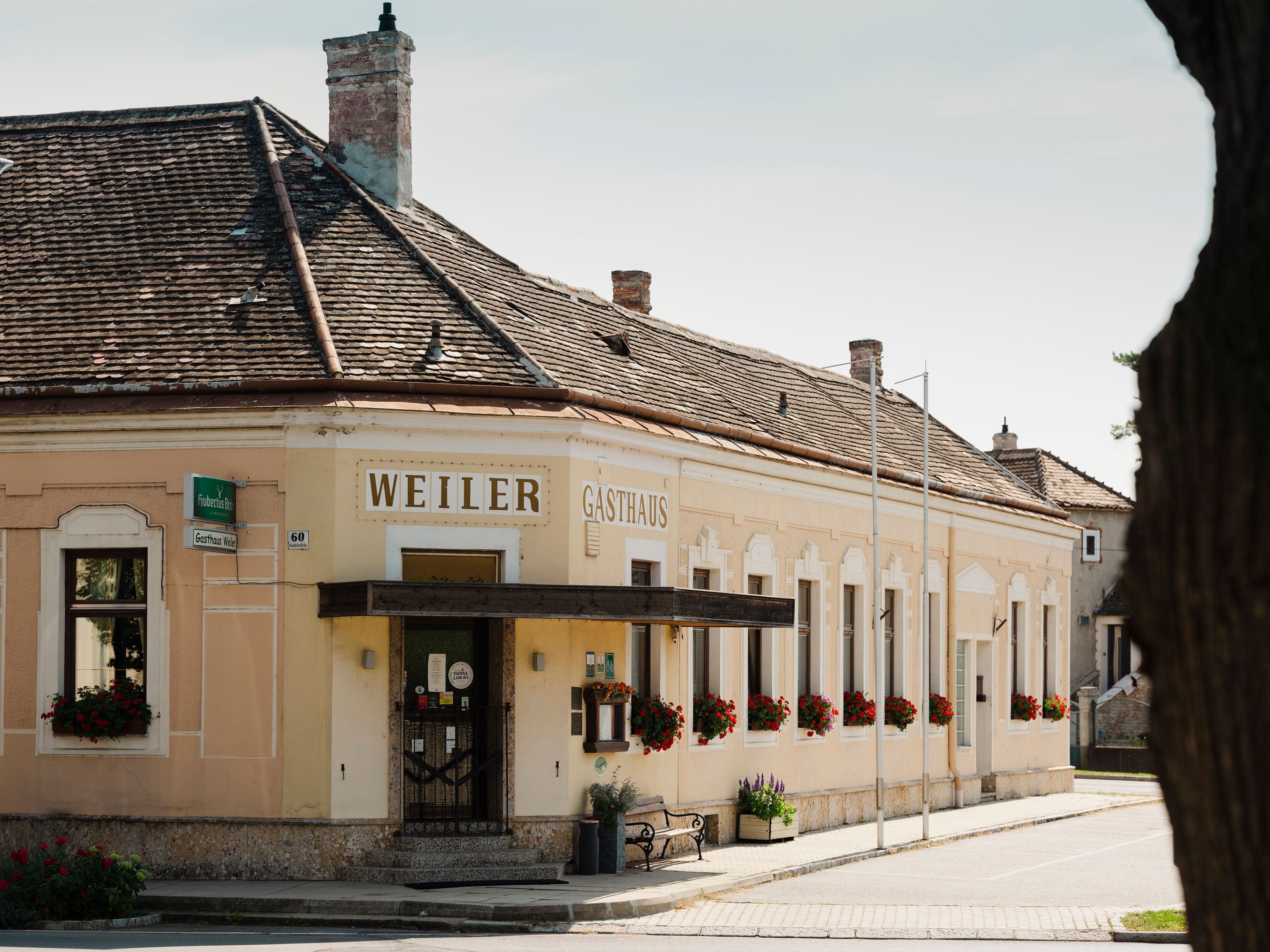 Historisches Gasthaus Weiler in Laa an der Thaya mit blumengeschmückten Fenstern.