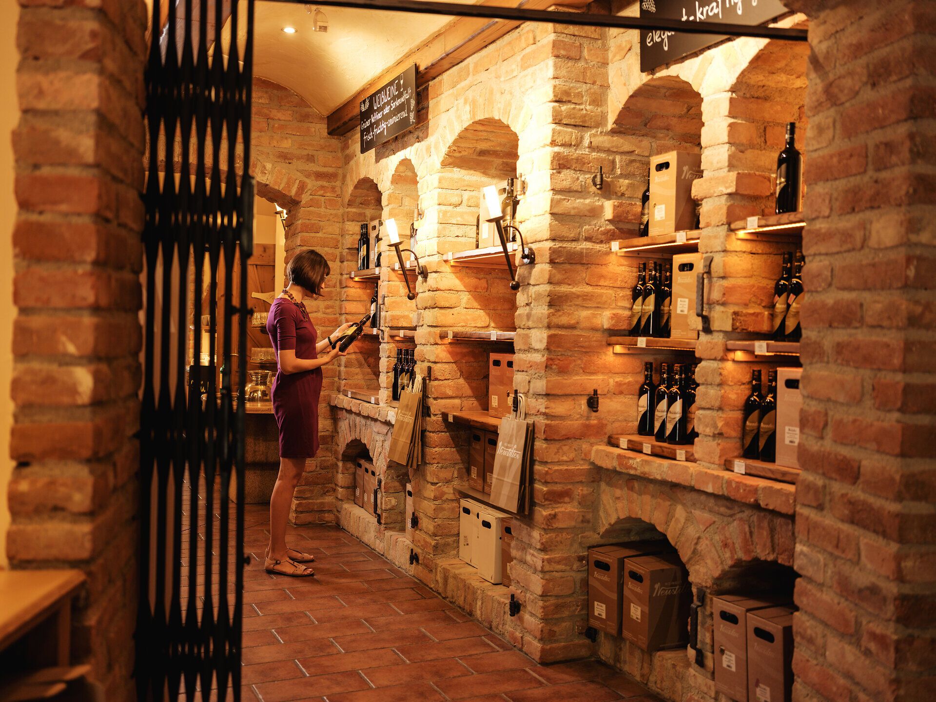 In der gemütlichen Vinothek erwartet Sie eine erlesene Auswahl an Weinen, die die Sinne verzaubert. Die warmen Ziegelwände und das sanfte Licht schaffen eine einladende Atmosphäre, ideal für Weinliebhaber und Genießer. Hier können Sie die Vielfalt der regionalen Weine entdecken und sich auf eine kulinarische Reise begeben.