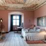 Elegantes Schlafzimmer mit antiker Decke, rosa W&auml;nden und Holzboden.