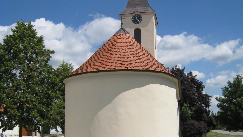 Chapel of St. Barbara with round roof and tower against a blue sky.
