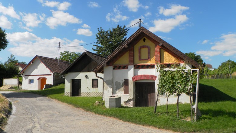 Traditionelle Weinkeller in einer ländlichen Umgebung mit blauem Himmel und Wolken.