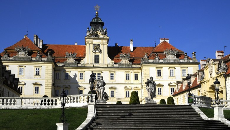 Schloss Valtice mit Treppe und Statuen im Vordergrund.