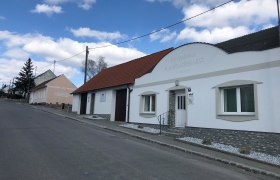 Straße mit Ferienhaus Kuckucksnest und blauen Himmel.