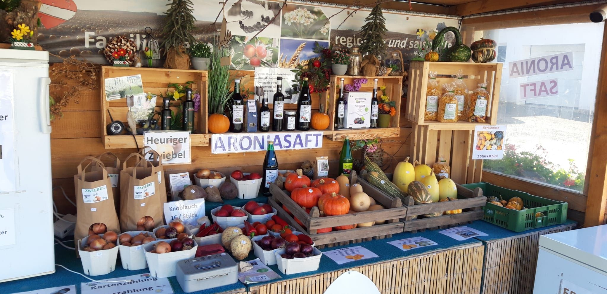 Ein Verkaufsstand mit regionalen Produkten wie Kürbissen, Zwiebeln und Aroniasaft.