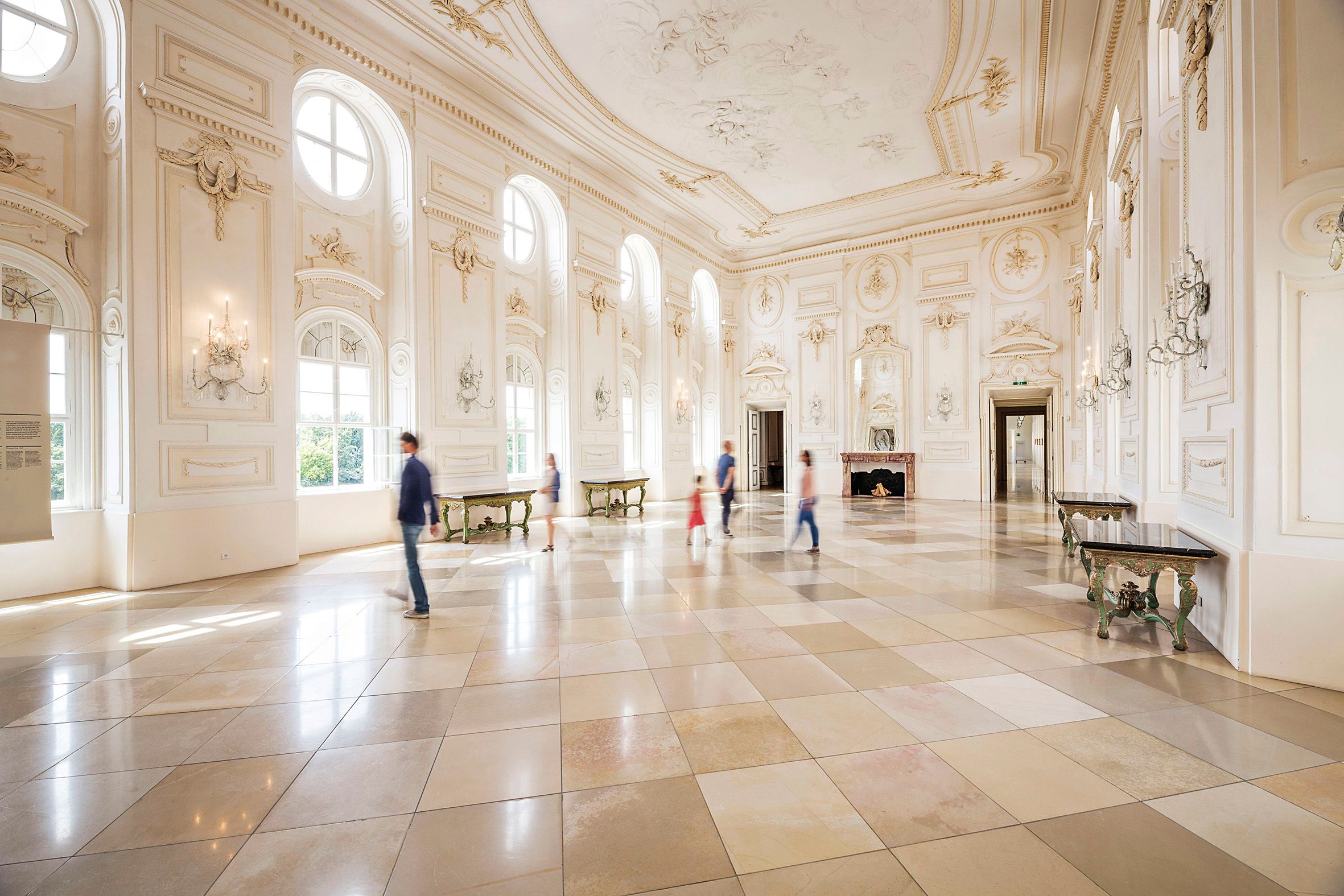 Large, bright ballroom with high windows and ornate walls in the Schloss Hof.