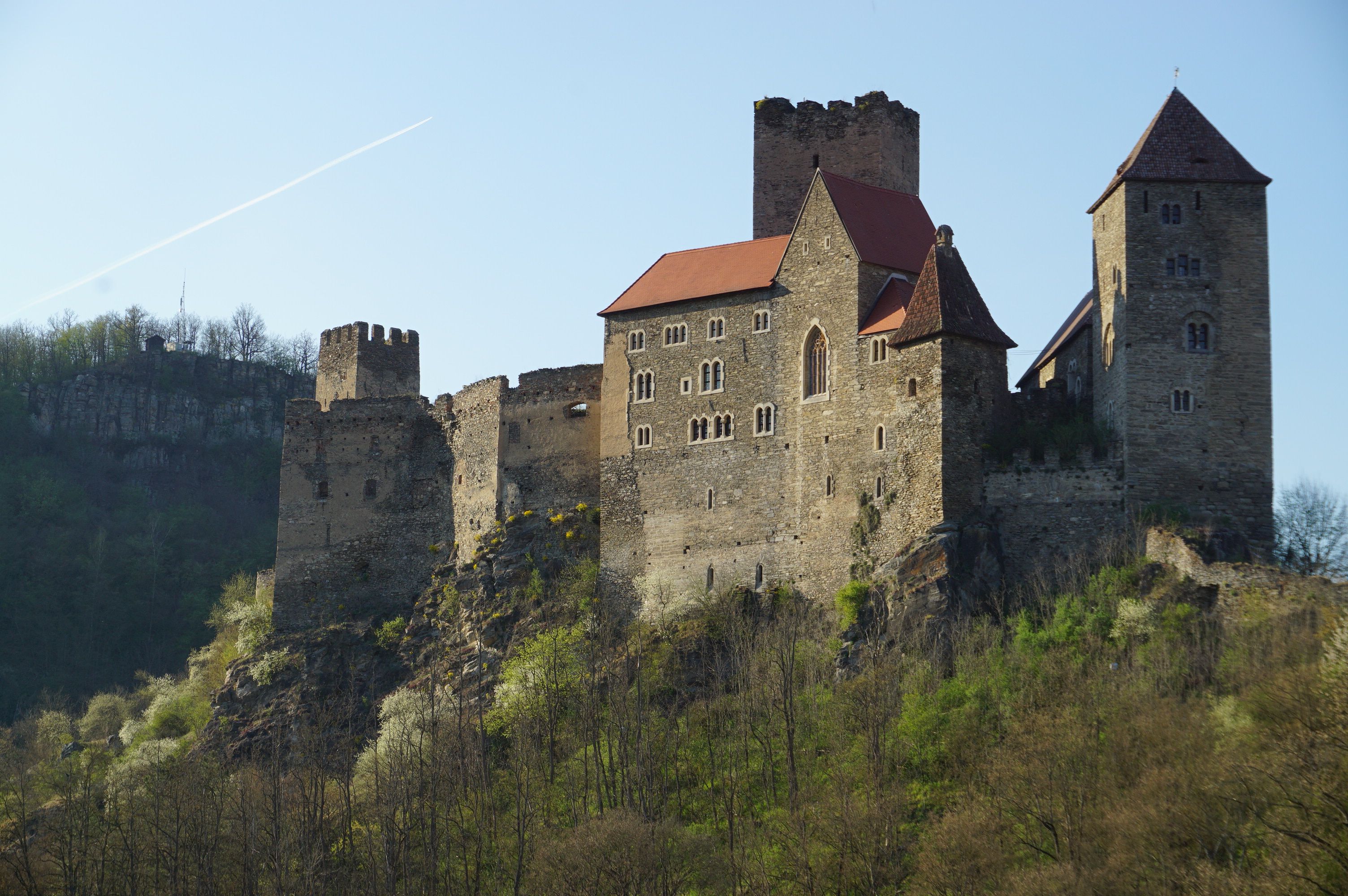 Hrad Hardegg na kopci se stromy v popředí.