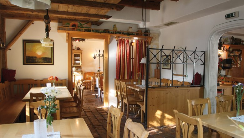 Innenansicht eines gemütlichen Heurigenlokals mit Holzmöbeln und rustikaler Dekoration.