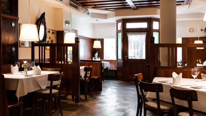 Cozy restaurant with wooden furniture and laid tables.