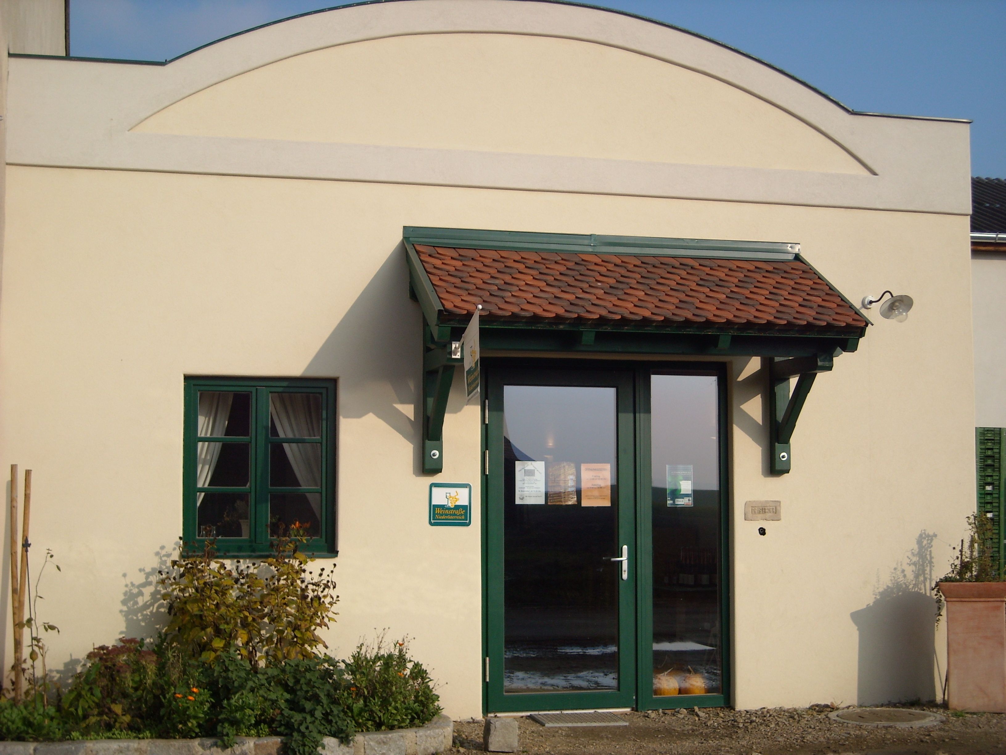 Entrance to a farm store with green door frame and small canopy.