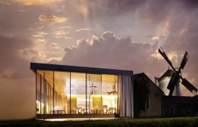 Moderne Glasarchitektur neben einer traditionellen Windmühle bei Sonnenuntergang.