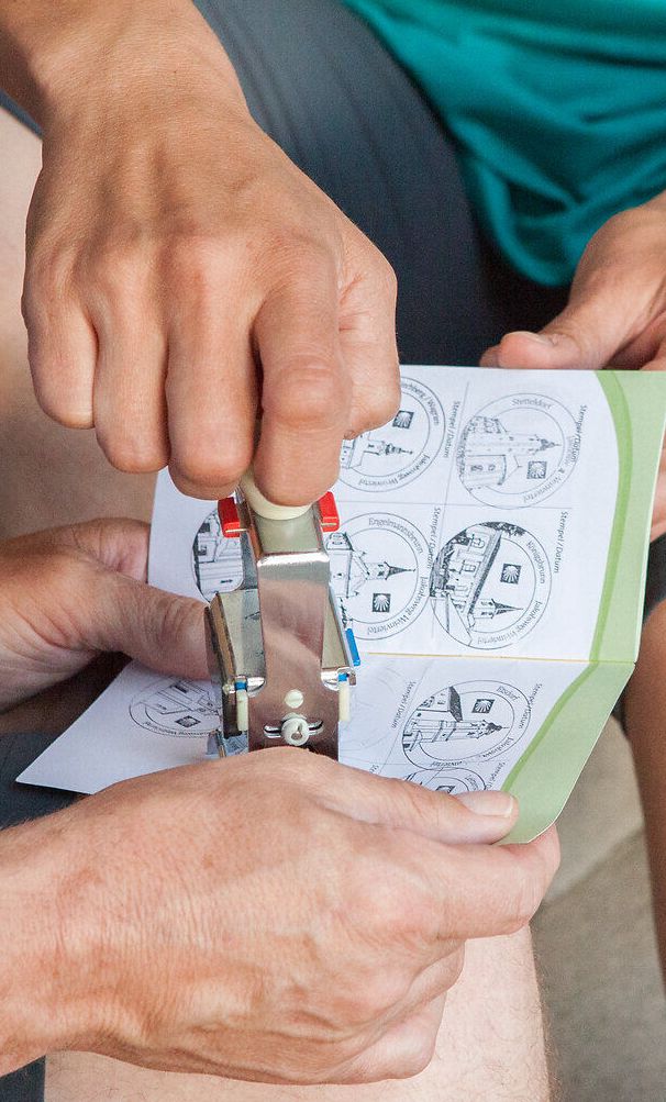 In einer entspannten Runde werden kreative Ideen ausgetauscht, während die Teilnehmer mit einem Stempel ihre Erlebnisse festhalten. Die Atmosphäre ist geprägt von Freude und Gemeinschaft, während die Vorfreude auf die bevorstehenden Abenteuer in den Bergen spürbar ist.