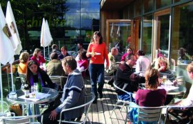 Menschen sitzen auf einer Terrasse eines Caf&eacute;s im Nationalpark Thayatal.