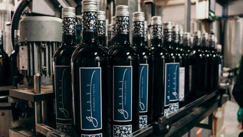 Weinflaschen auf einem F&ouml;rderband in einer Abf&uuml;llanlage.