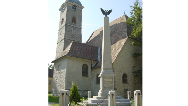 Kirche mit Turm und Denkmal in Ulrichskirchen.