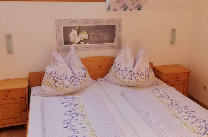 Gem&uuml;tliches Schlafzimmer mit Dachfenstern und Blumenbettw&auml;sche.