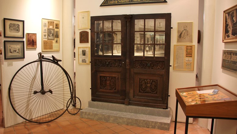 Innenansicht des Bezirksmuseums Stockerau mit Hochrad und historischen Ausstellungsstücken.