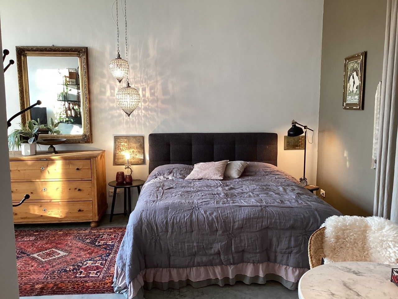 Gemütliches Schlafzimmer mit Doppelbett, Holzmöbeln und orientalischem Teppich.