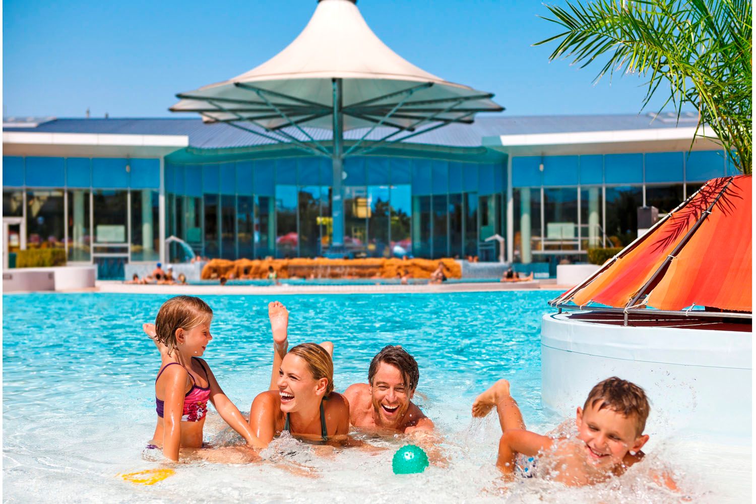Familie spielt im Außenpool der Therme Laa/Thaya.