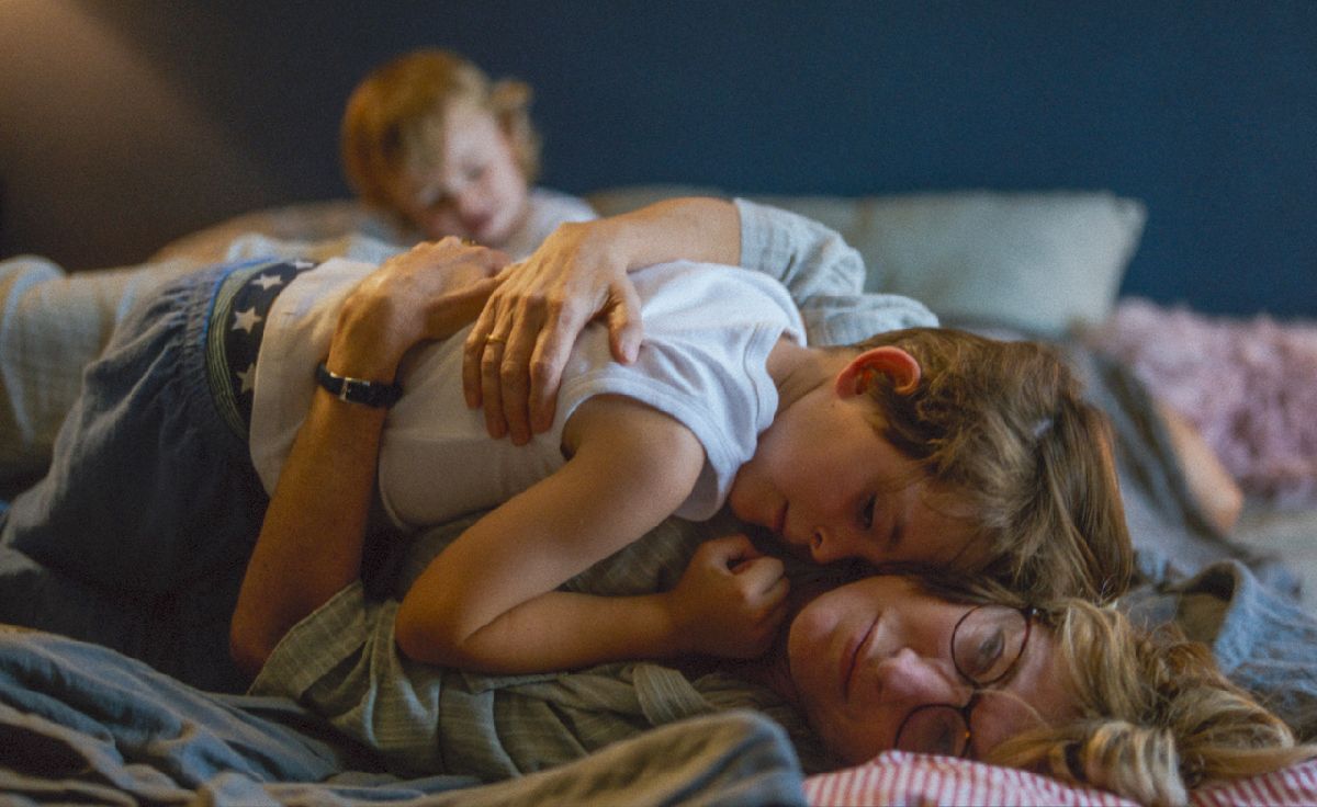 Eine Person und ein Kind, die auf einem Bett liegen