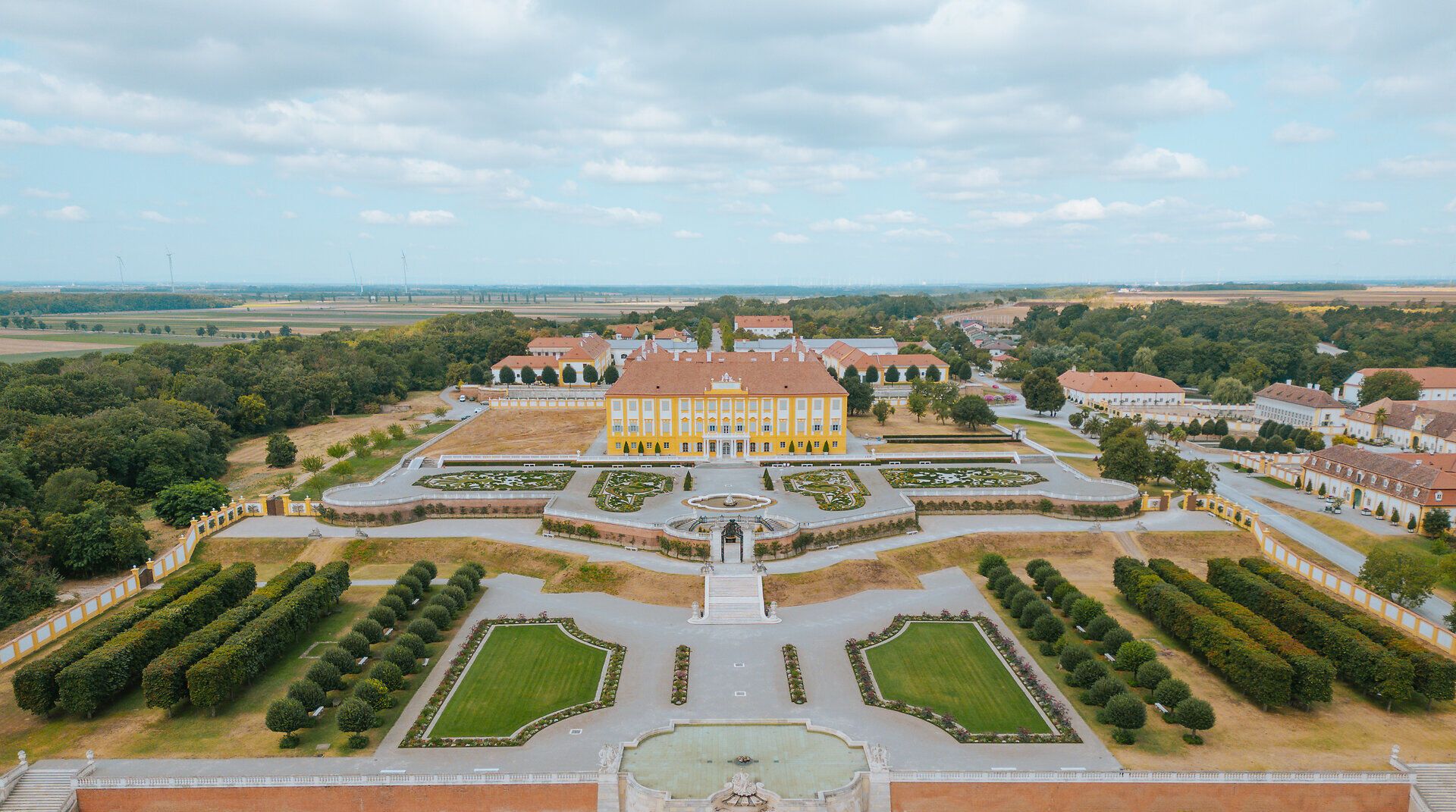 Die weitläufigen Terrassen von Schloss Hof laden zu einem entspannenden Spaziergang ein, umgeben von kunstvoll gestalteten Gärten und prächtigen Pflanzen. Hier entfaltet sich die Schönheit der Natur in harmonischer Verbindung mit der historischen Architektur, während sanfte Brisen die Luft erfüllen und die Sinne beleben.