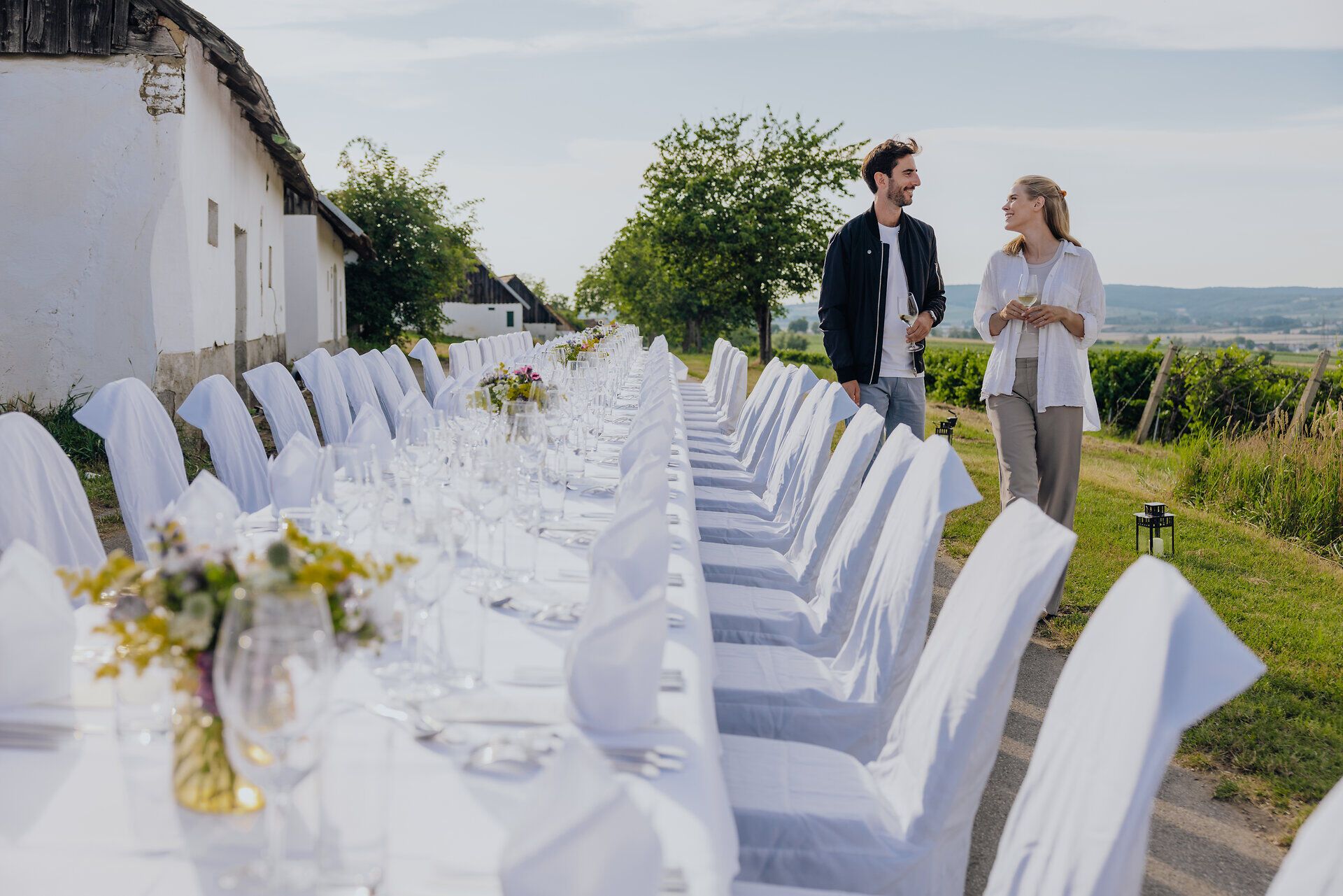 Inmitten der sanften Hügel des Weinviertels erstreckt sich eine festlich gedeckte Tafel, umgeben von üppigen Weinreben. Die warme Sonne taucht die Szenerie in ein goldenes Licht und lädt dazu ein, die kulinarischen Köstlichkeiten der Region zu genießen. Ein perfekter Ort für gesellige Stunden und unvergessliche Erlebnisse.