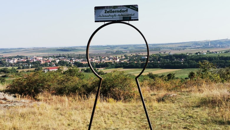 Blick auf Zellerndorf durch eine schlüsselförmige Metallskulptur.