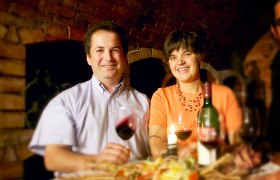 Ein Mann und eine Frau sitzen an einem Tisch mit Wein und Kerze.