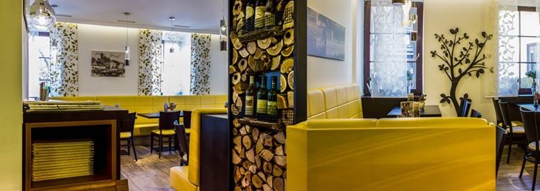 Innenansicht eines Restaurants mit gelben Sitzbänken und dekorativen Elementen.