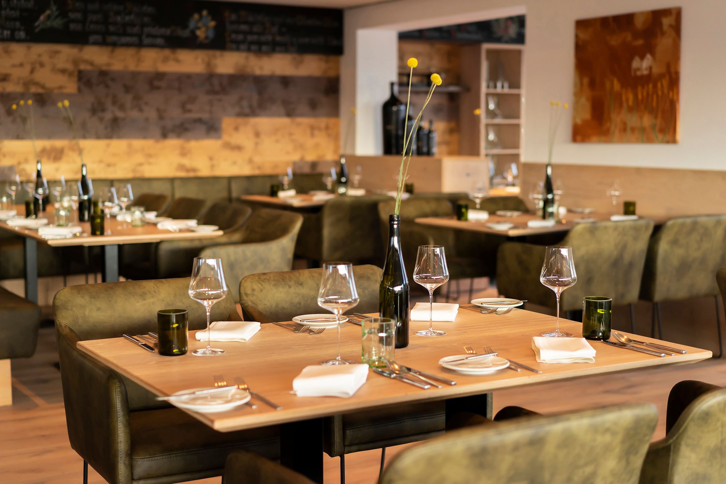 Elegantes Restaurant mit gedeckten Tischen, Weingläsern und stilvoller Dekoration.