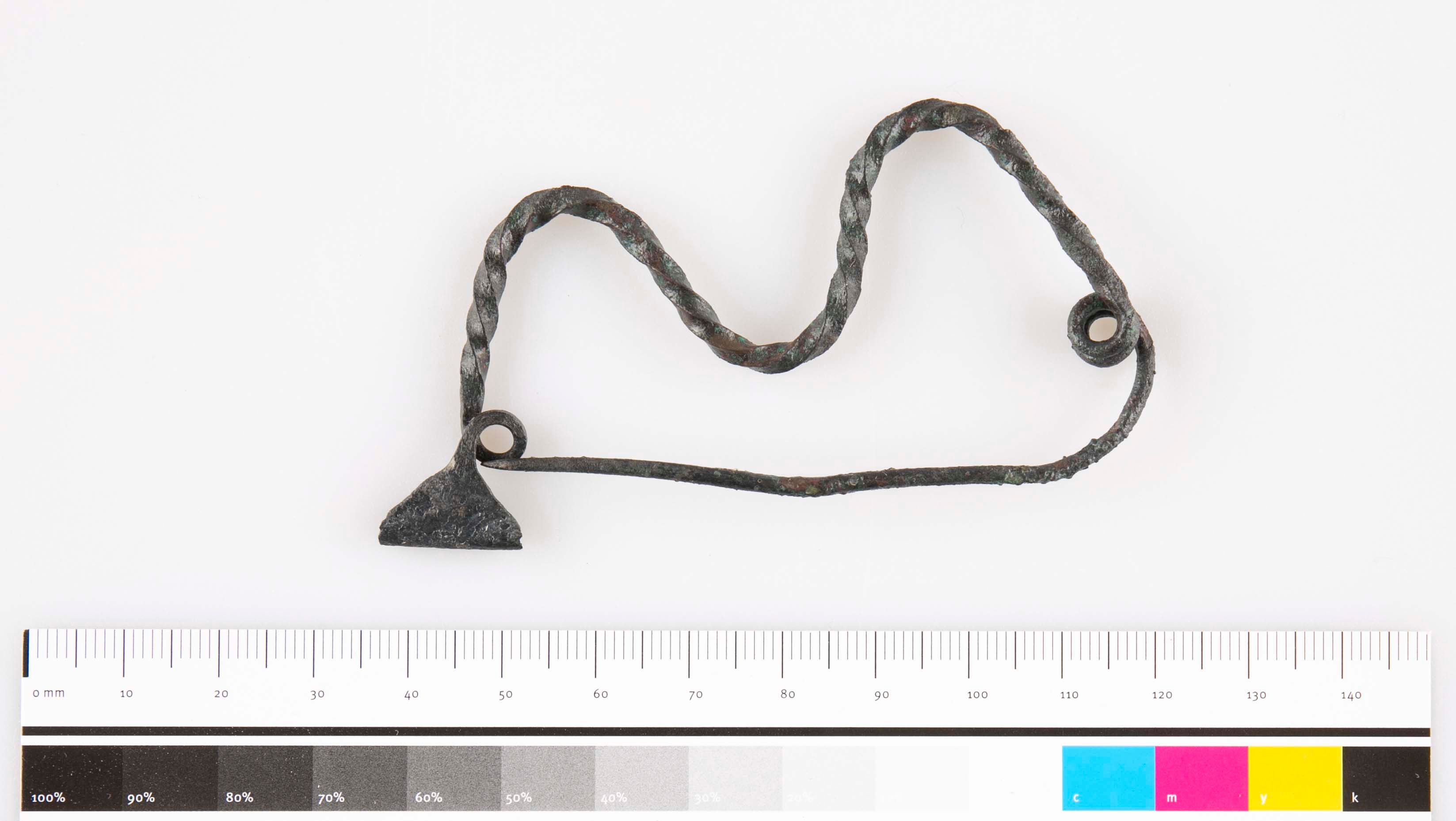 Metallobjekt mit verdrehtem Draht und Maßstab.