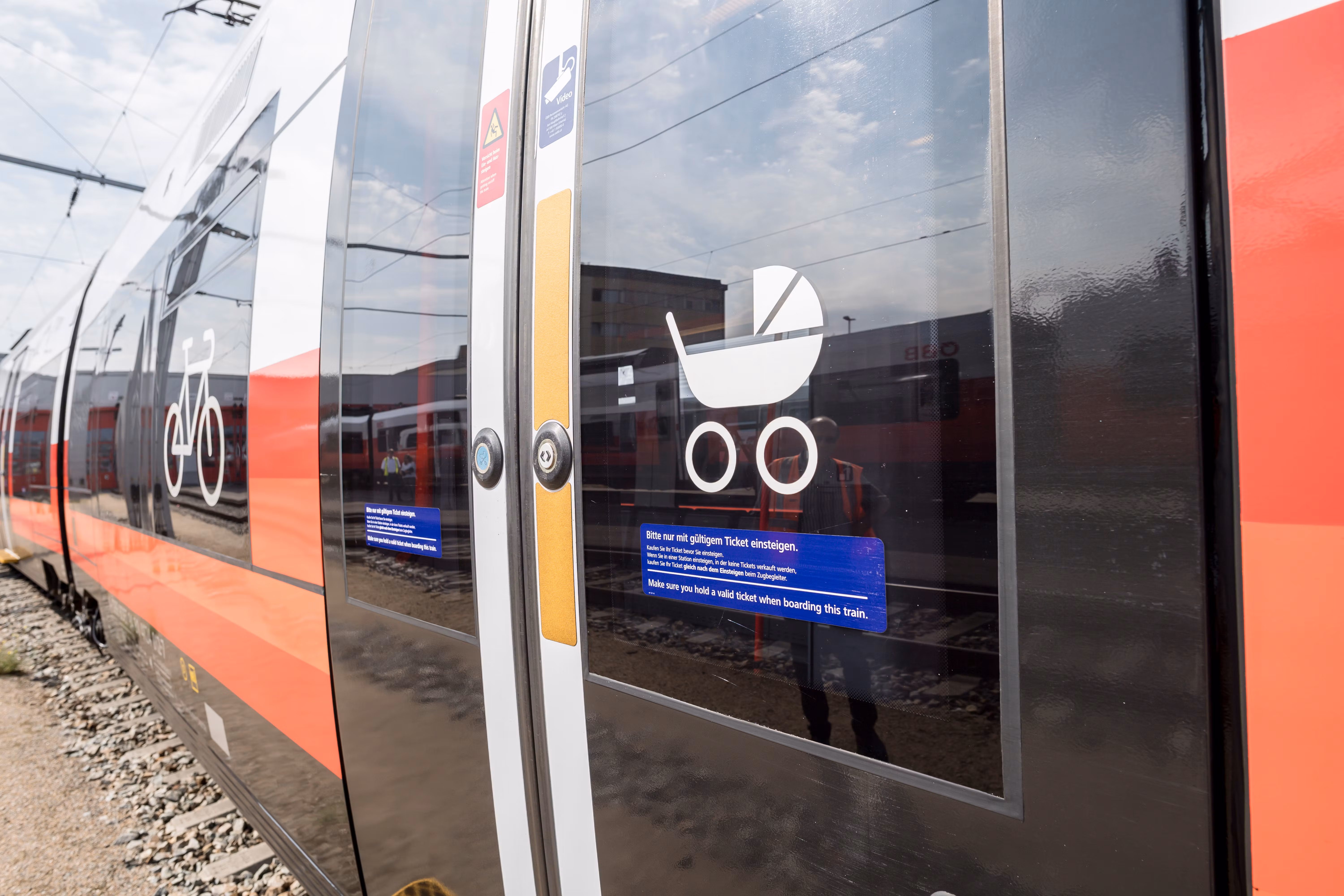 Close-up of a train door with symbols for bicycles and baby carriages.