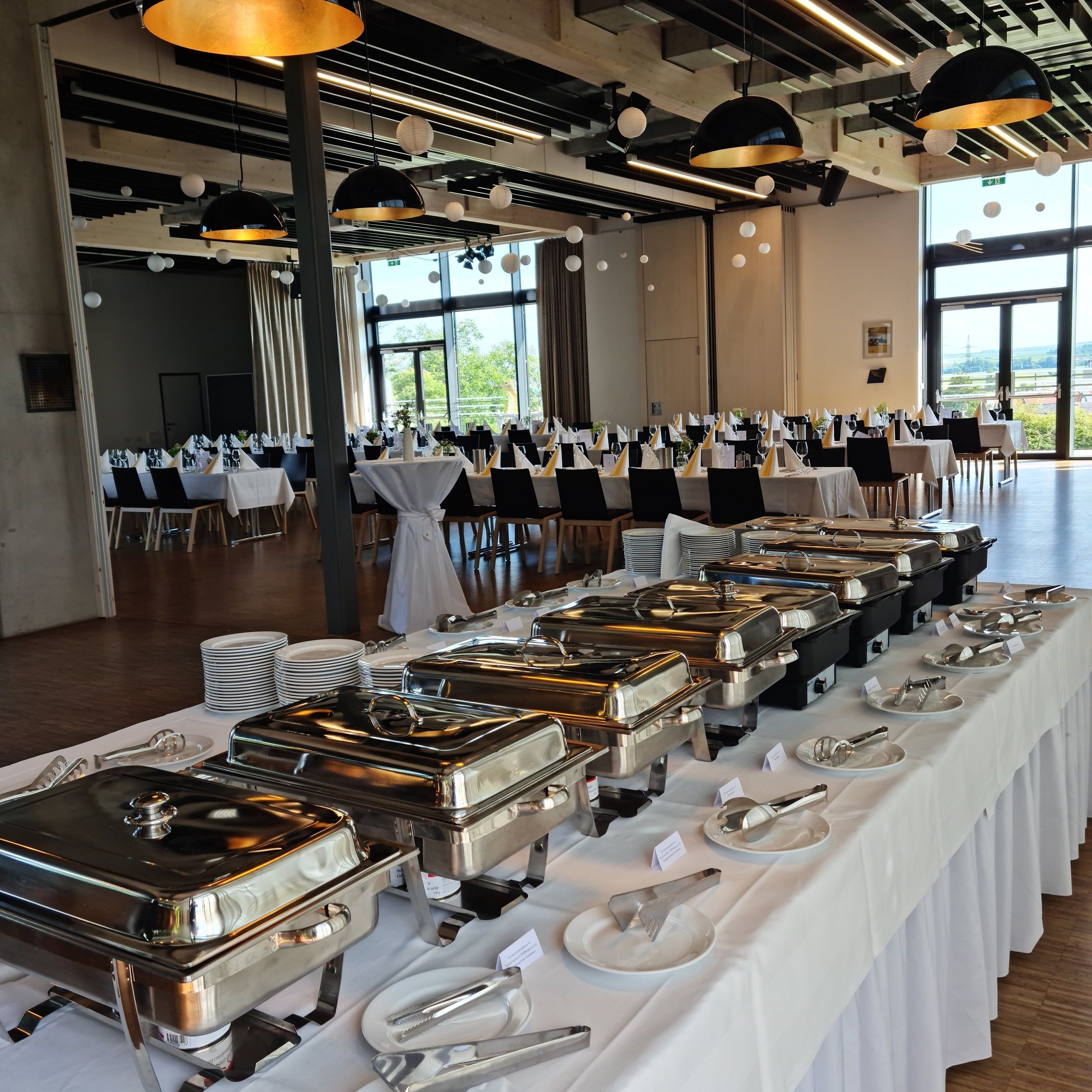 A festively decorated room with a buffet and laid tables.