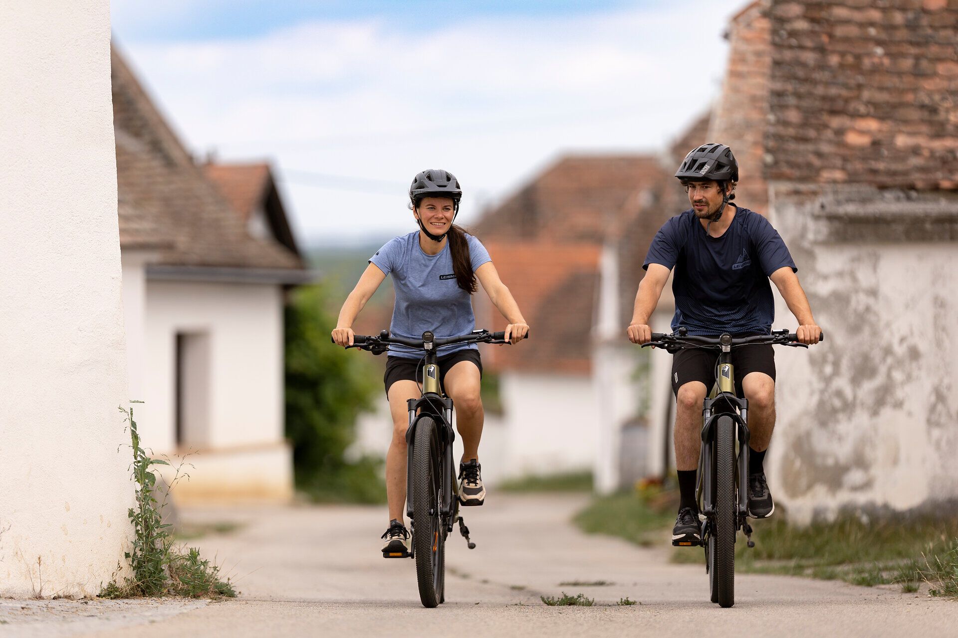 In der malerischen Kellergasse Maulavern radeln zwei begeisterte Radfahrer durch die idyllische Landschaft des Weinviertels. Umgeben von sanften Hügeln und üppigen Weinreben genießen sie die frische Luft und die Ruhe der Natur. Ein perfekter Tag für eine Entdeckungstour auf zwei Rädern.
