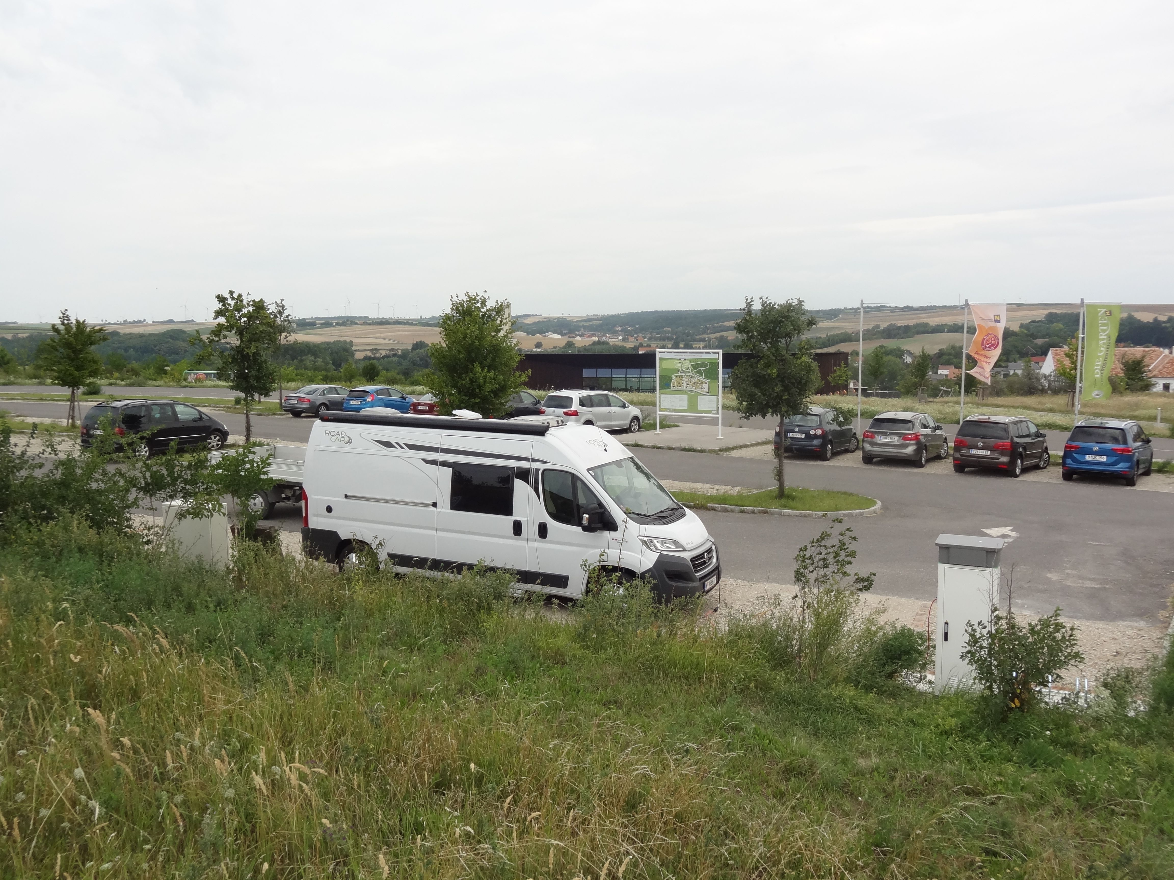Wohnmobil auf einem Parkplatz mit umliegender Landschaft.