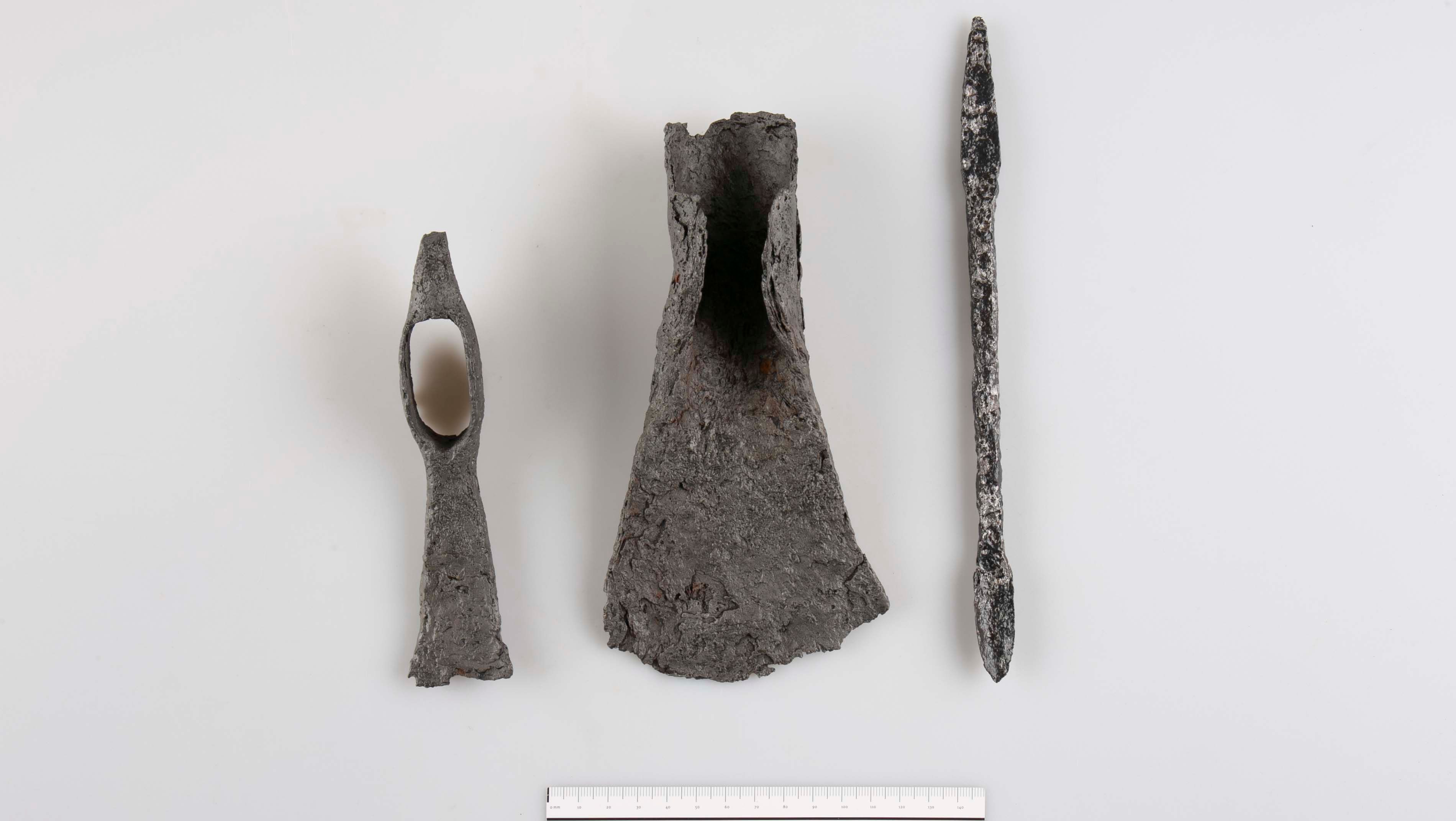 Three archaeological metal objects on a white background with scale at the bottom.
