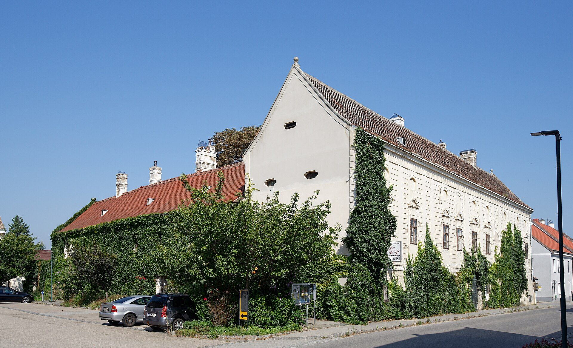 Haugsdorf Castle with overgrown façade and blue sky.