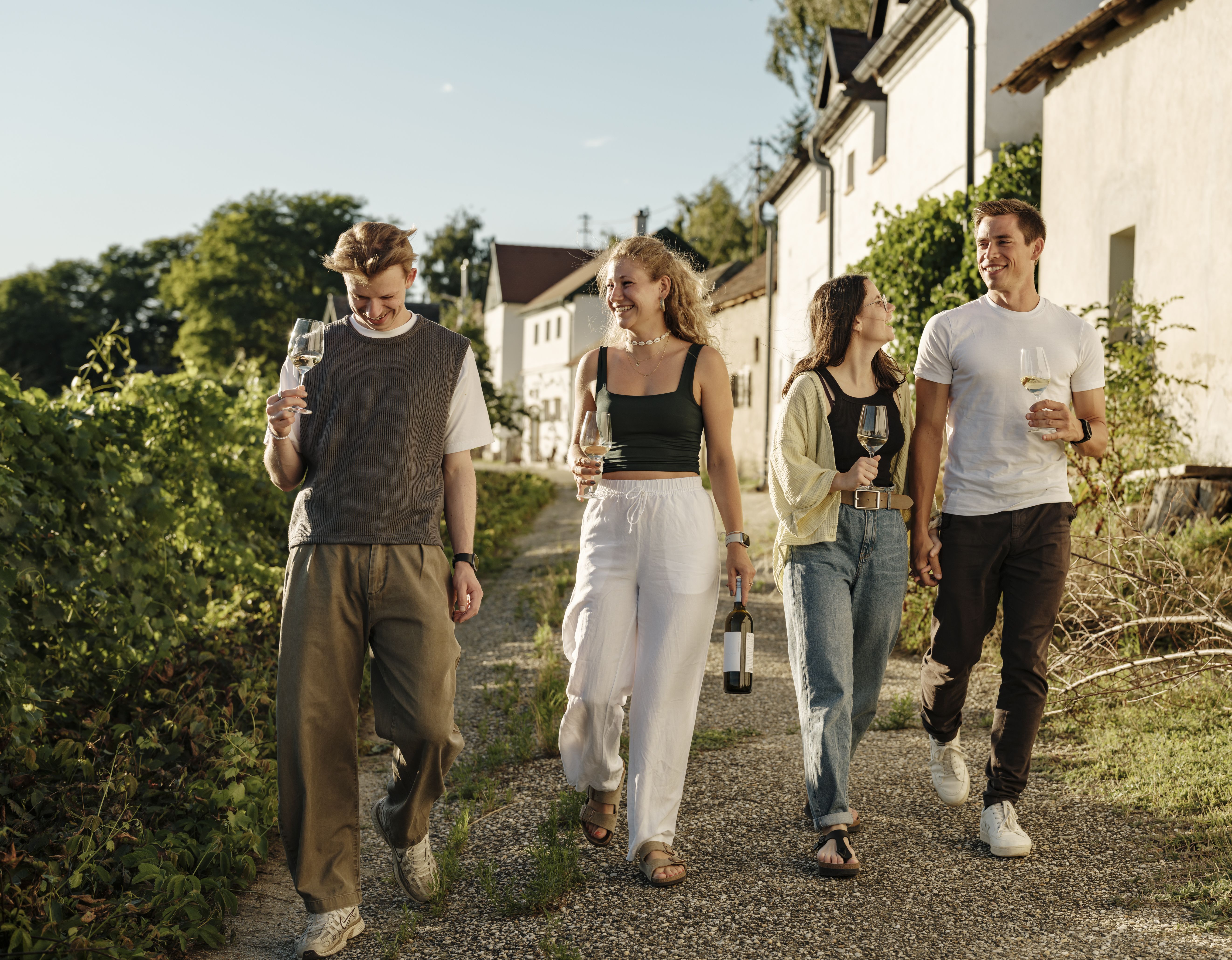 Vier Personen spazieren durch eine Kellergasse.
