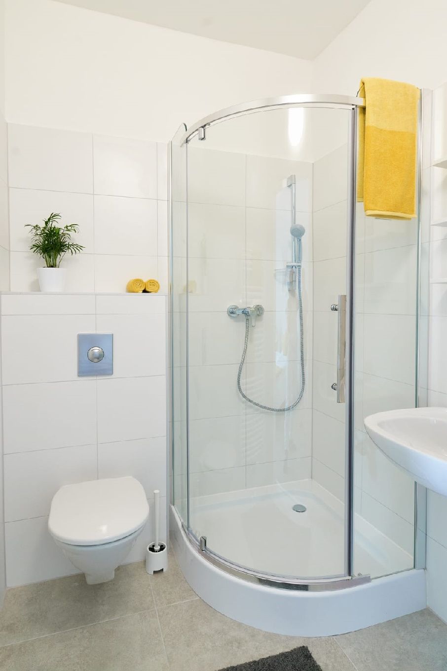 Modernes Badezimmer mit Dusche, Toilette und Waschbecken.