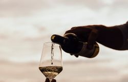 Ein sanfter Sonnenstrahl bricht durch die Wolken und taucht die Weinlandschaft in ein warmes Licht. Ein elegantes Weinglas füllt sich mit spritzigem Wein, während die frische Luft den Duft von blühenden Reben trägt. Hier wird der Genuss zelebriert und die Gelassenheit des Lebens in vollen Zügen ausgekostet.