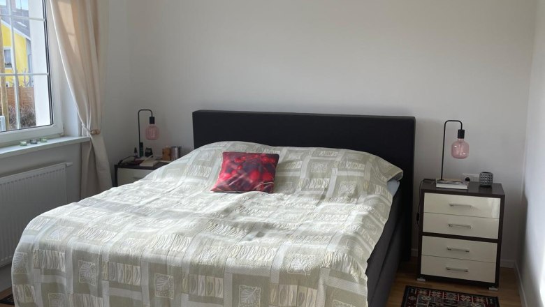 Ein Schlafzimmer mit einem Doppelbett, zwei Nachttischen und Teppichen auf Holzboden.