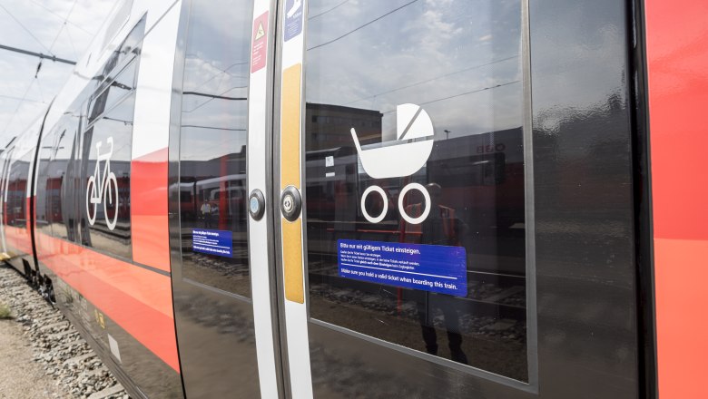Close-up of a train door with symbols for bicycles and baby carriages.