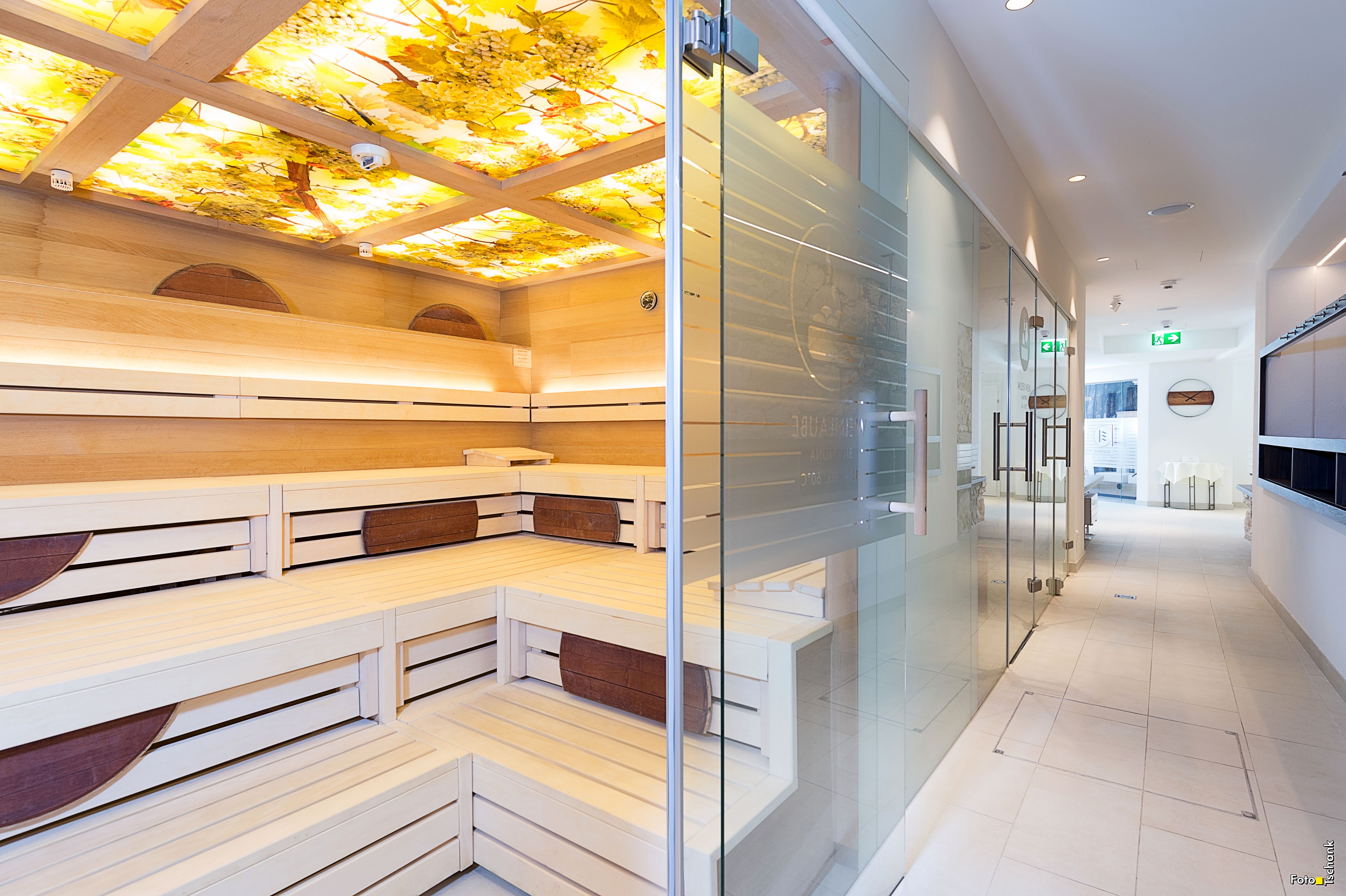 Innenansicht eines modernen Spa-Bereichs mit Sauna und Glastür.