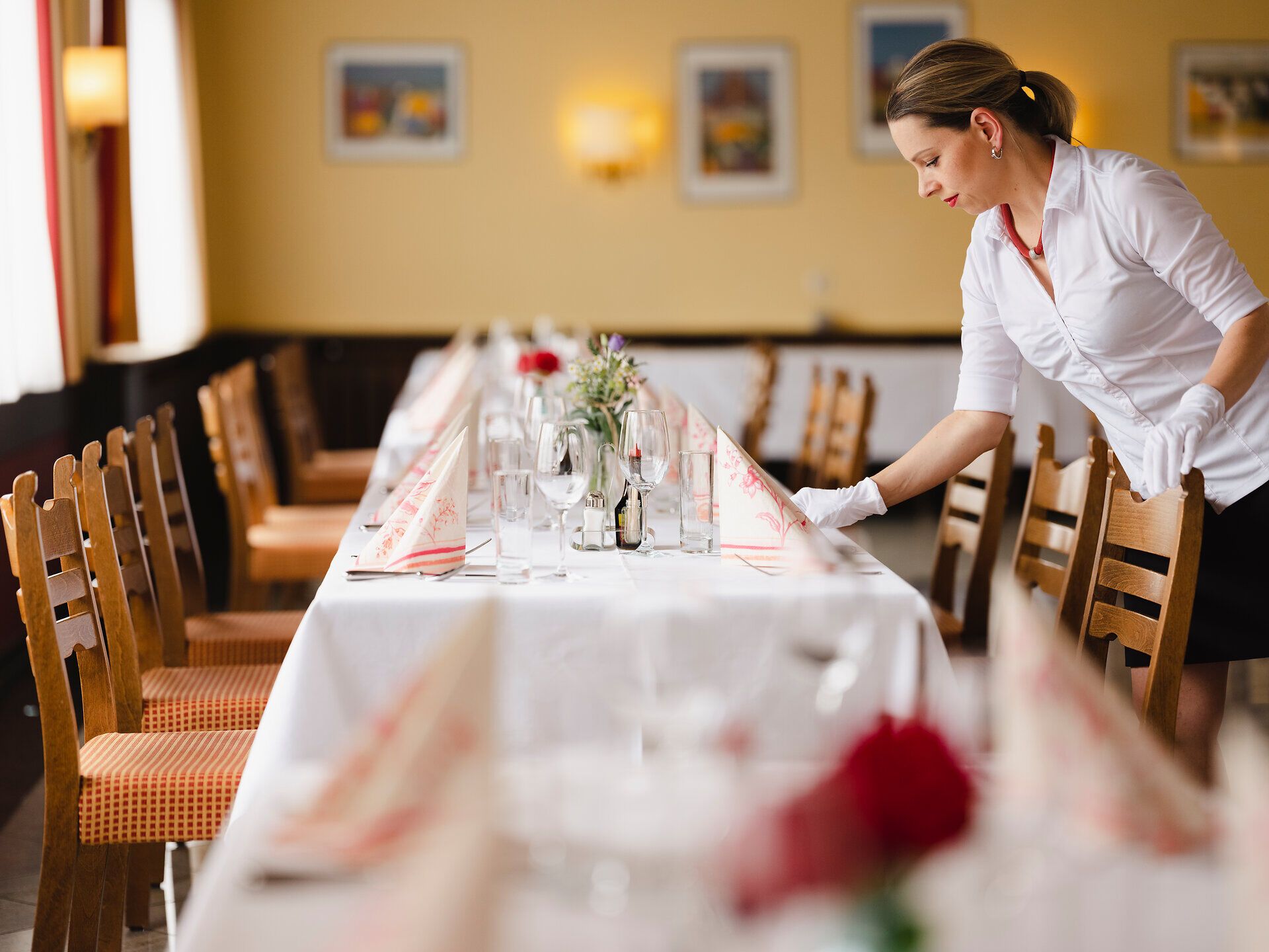 In einem einladenden Wirtshaus wird der Tisch für die Gäste liebevoll gedeckt. Die frischen Blumen und das elegante Geschirr schaffen eine warme Atmosphäre, die zum Verweilen einlädt. Hier im Weinviertel erleben Besucher die herzliche Gastfreundschaft und die kulinarischen Köstlichkeiten der Region.