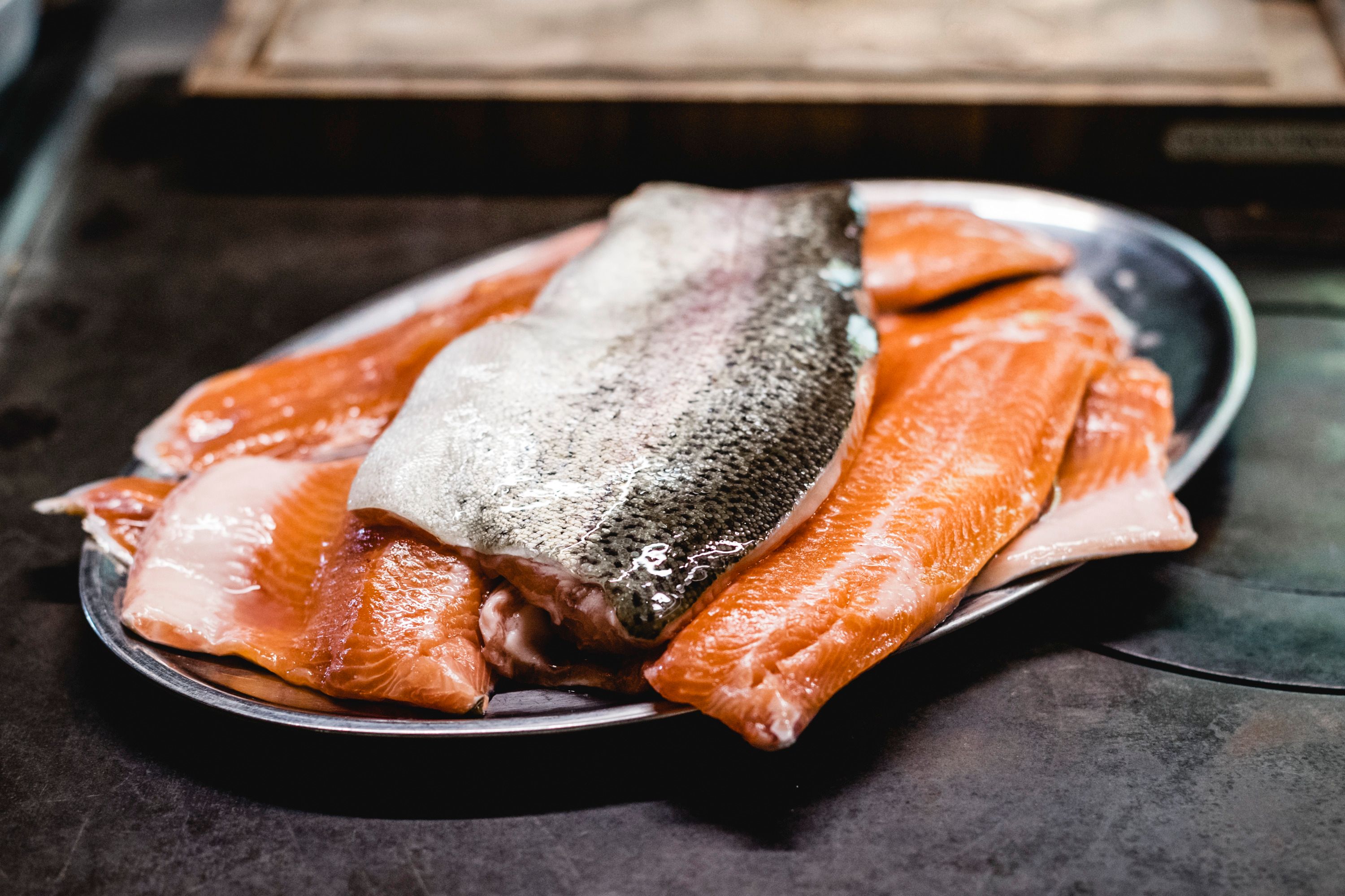 Frische Lachsfilets auf einem Metalltablett.