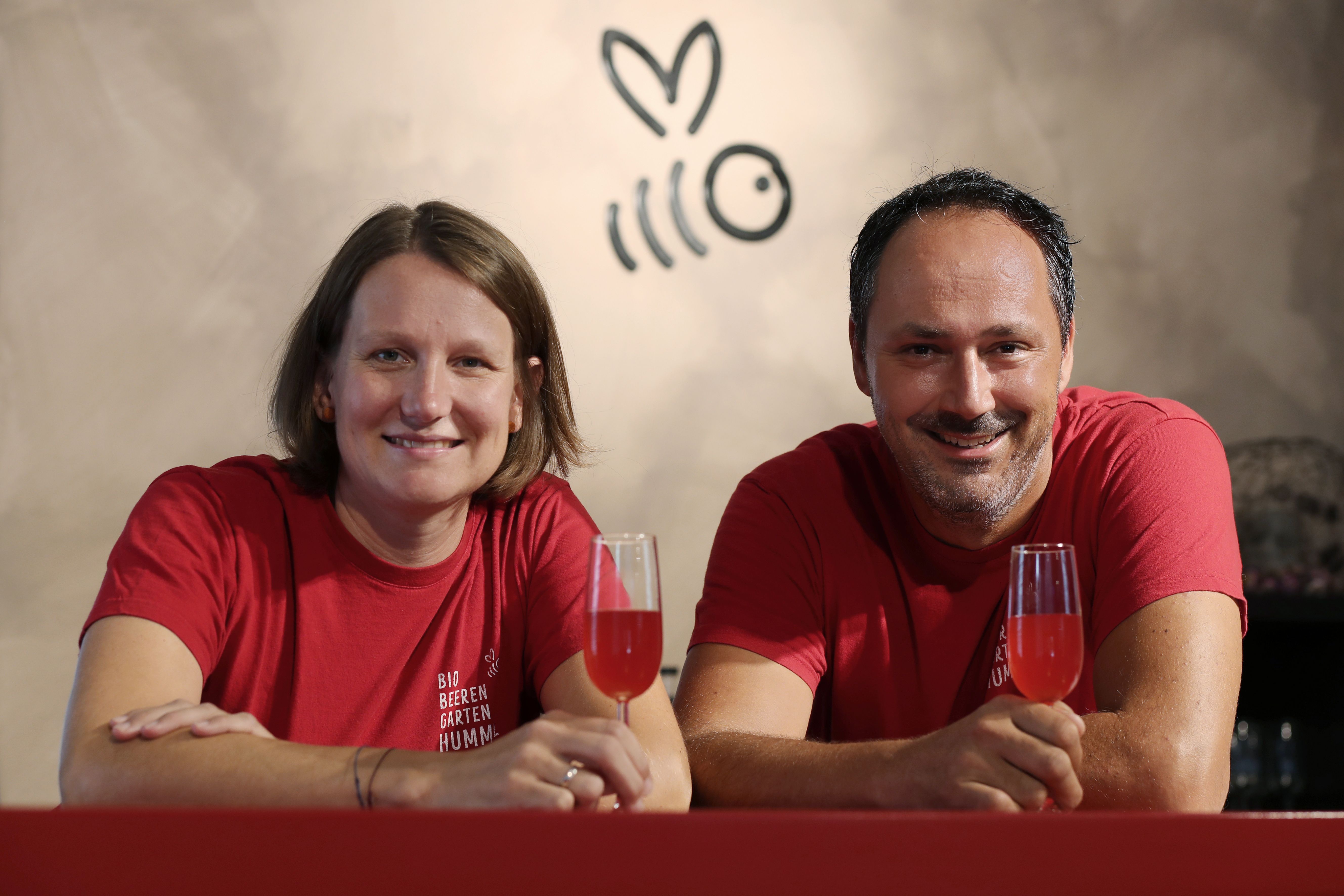 Ein Mann und eine Frau konsumieren ein Himbeer-Getränk und strahlen.