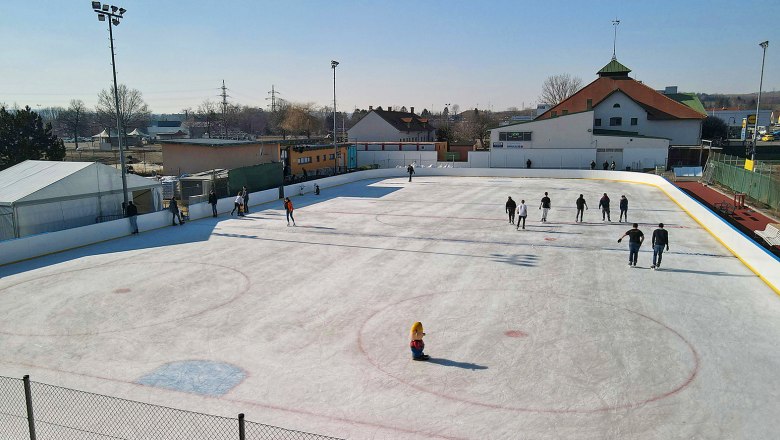 Eislaufbahn mit Menschen in Hollabrunn bei sonnigem Wetter.
