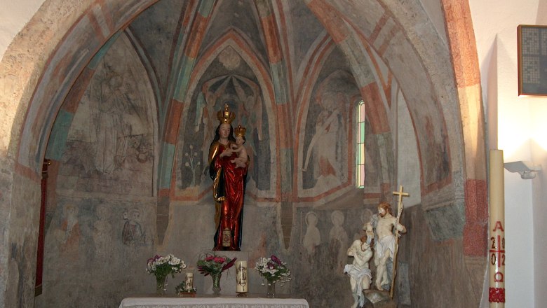 Interior view of a chapel with frescoes and statues.